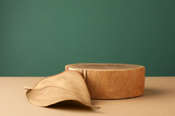 Presentation for product. Wooden podium and dry leaf on color background. Space for text