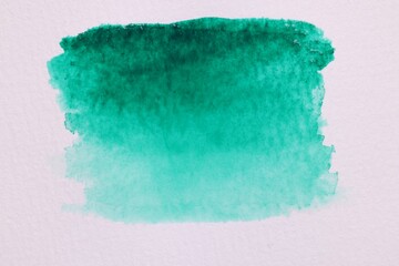 Abstract green watercolor painting on white paper, top view