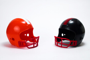Red and black miniature american football helmets with white background