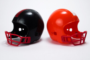 Red and black miniature american football helmets with white background
