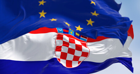 The flags of Croatia and the European Union fluttering together on a clear day
