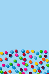 Multicolored candies on a bright blue background. Colorful summer idea.Flat lay.