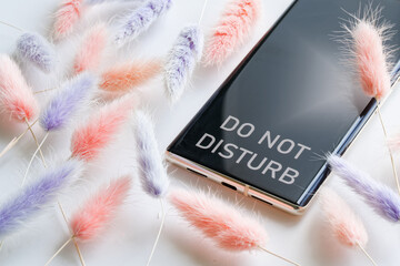 Cell phone - a smartphone with the inscription do not disturb and fluffy red and blue flowers. The...
