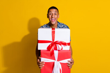 Photo of excited good mood guy wear print shirt buying christmas presents empty space isolated yellow color background