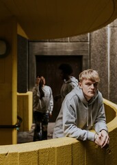 Fototapeta premium Man in gray hoodie at yellow stairs