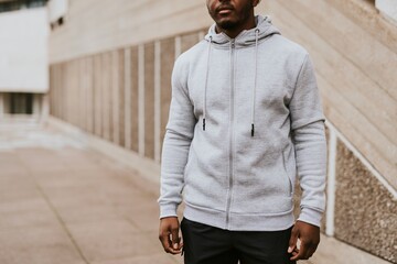 Man in gray zip up hoodie by staircase