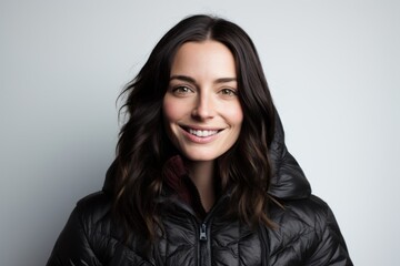 Obraz premium Portrait of a glad woman in her 30s sporting a quilted insulated jacket in front of white background