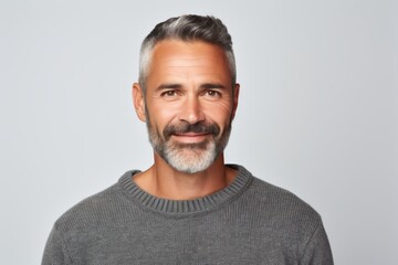 Fototapeta premium Portrait of a glad man in his 40s wearing a cozy sweater in white background