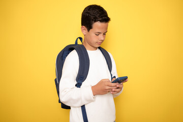 Teenager boy wearing headphones and using smartphone over isolated background