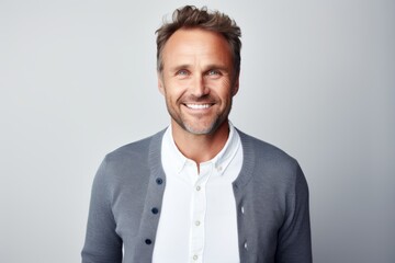Portrait of a smiling man in his 40s wearing a chic cardigan isolated on white background
