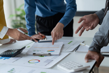 close-up hands image, Professional Asian male and female financial consultant or analyst working with them team, brainstorming and analyzing financial data on the report together in the office