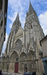 Bayeux, France - Apr 28, 2024: Bayeux Cathedral. Streets and buildings. Lifestyle in the urban area. Sunny spring day. Selective focus