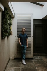 Man in blue tee standing in front of white door