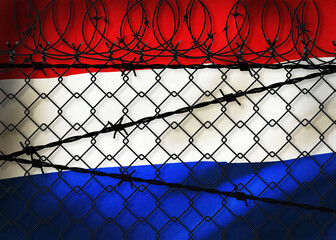 Netherlands flag behind barbed wire and metal fence