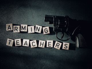 Guns for teachers wood letters text message black background