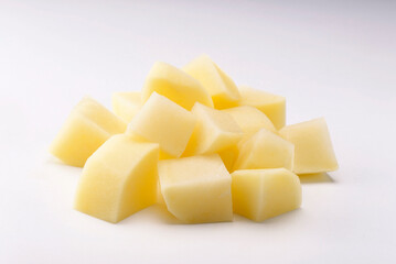 raw potato cut into square pieces on white background