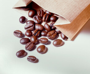 roasted coffee beans in paper bag on white background