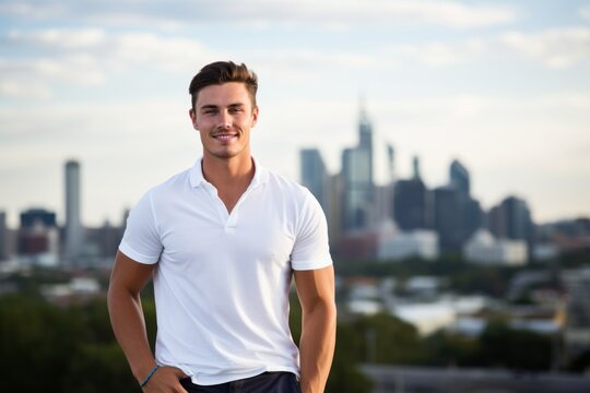 Portrait of a grinning man in his 20s wearing a sporty polo shirt on vibrant city skyline