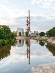 A power station in the centre of Wrocław, Poland, reflects beautifully along with the trees, sky,...