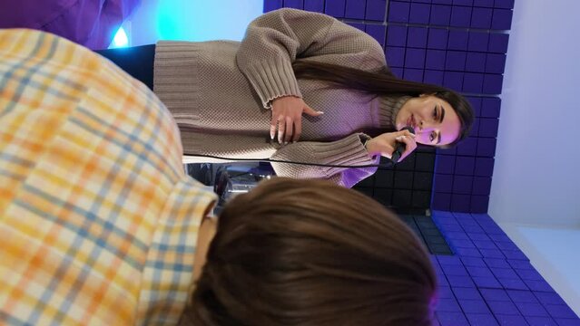 Instructor listens to student voice during lesson in studio. Teacher gives tailored instruction helping to develop vocal abilities