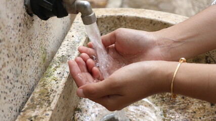 close up of a woman washing her hands at the sink - Powered by Adobe