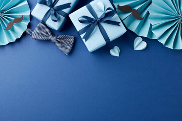 Flat lay captures the essence of Father's Day with stylishly wrapped gifts, a bow tie, and playful...