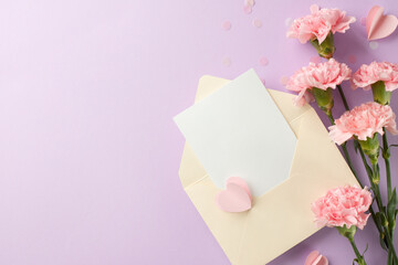 Elegant flat lay setup featuring a pastel envelope, blank card, and pink carnations, perfect for writing a heartfelt Mother's Day message