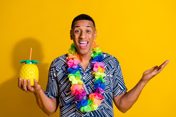 Photo of handsome impressed guy wear print shirt hawaii necklace enjoy fruit juice isolated yellow...