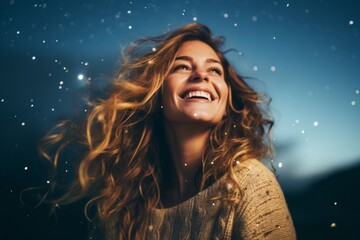 Portrait of a smiling woman in her 20s dressed in a warm wool sweater in sparkling night sky