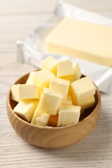 Tasty butter on light wooden table, closeup
