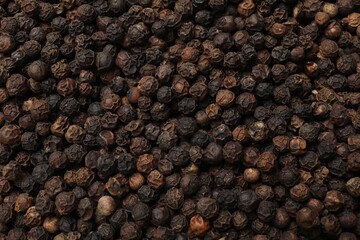 Aromatic spice. Black peppercorns as background, top view