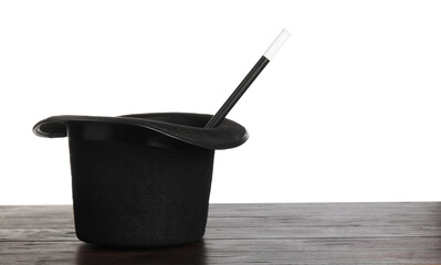 Magician's hat and wand on wooden table against white background