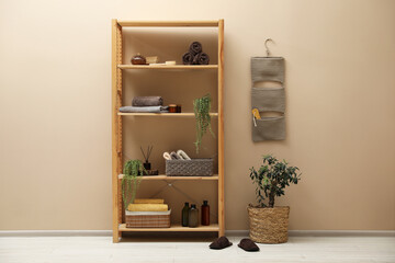 Shelving unit with soft towels, plants and bottles indoors
