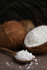 Coconut flakes and spoon on brown table
