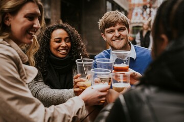 Diverse friends drinking beer in plastic cups