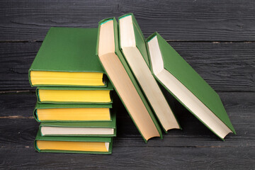 Books on wooden table, black board background. Back to school. Education business concept.
