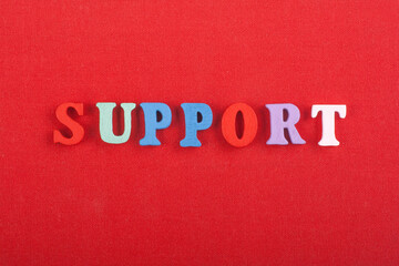 SUPPORT word on red background composed from colorful abc alphabet block wooden letters, copy space...