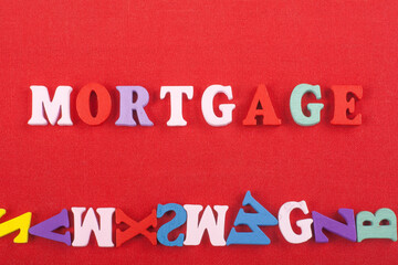 MORTGAGE word on red background composed from colorful abc alphabet block wooden letters, copy...