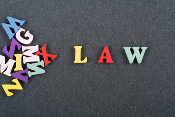 LAW word on black board background composed from colorful abc alphabet block wooden letters, copy...