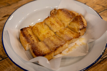 Sliced bread with butter, milk and sugar served on plate