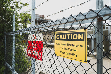 Shallow focus of Caution and No Parking signs seen at the entrance to a chemical plant in the UK....