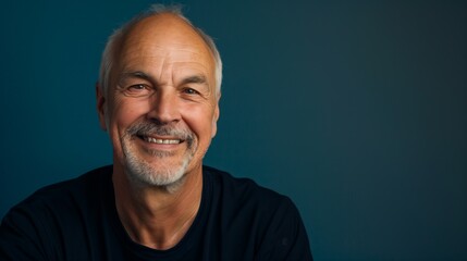 Obraz premium Portrait of an every day man, bald and smiling against a solid blue background