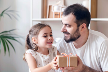 Happy little daughter gives a gift to her dad. Father's day celebration. AI generated