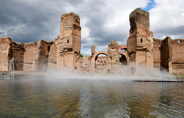 Walls of the Baths of Caracalla in Rome, artificial pool in the foreground inaugurated in 2024 with...