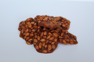 Gula kacang, or Ampyang, is a traditional snack from Indonesia, made from roasted peanuts and brown sugar. Isolated on white background
