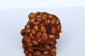 Gula kacang, or Ampyang, is a traditional snack from Indonesia, made from roasted peanuts and brown sugar. Isolated on white background