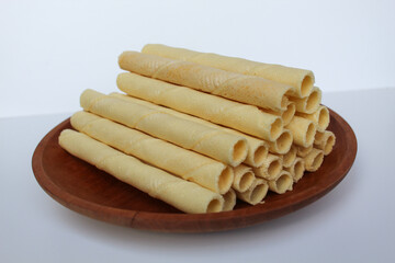 Egg rolls, original flavor. Rolled thin crepes. On wooden plate. Isolated on white background