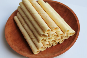 Egg rolls, original flavor. Rolled thin crepes. On wooden plate. Isolated on white background