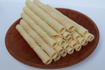 Egg rolls, original flavor. Rolled thin crepes. On wooden plate. Isolated on white background