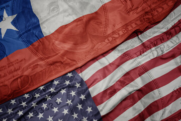 Obraz premium waving colorful flag of united states of america and national flag of chile on the dollar money background. finance concept.